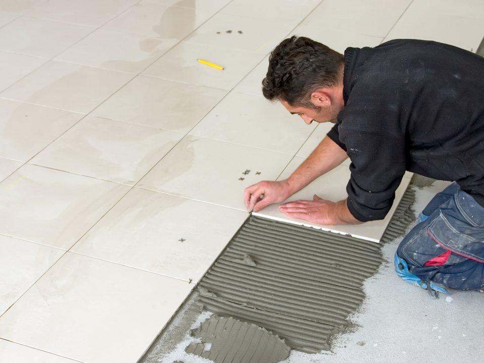 Man installs ceramic tiles